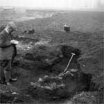 Photograph of ET Leeds beside a trench
